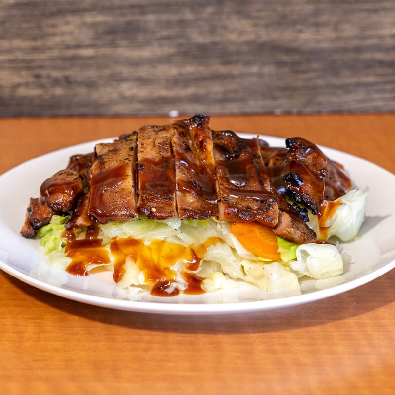 Grilled Hawaiian BBQ chicken, sliced and drizzled with sauce, served over a bed of lettuce.
